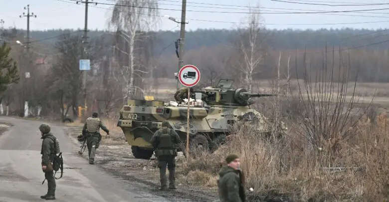 Ukrainian servicemen stand near an armored personnel carrier BTR-3