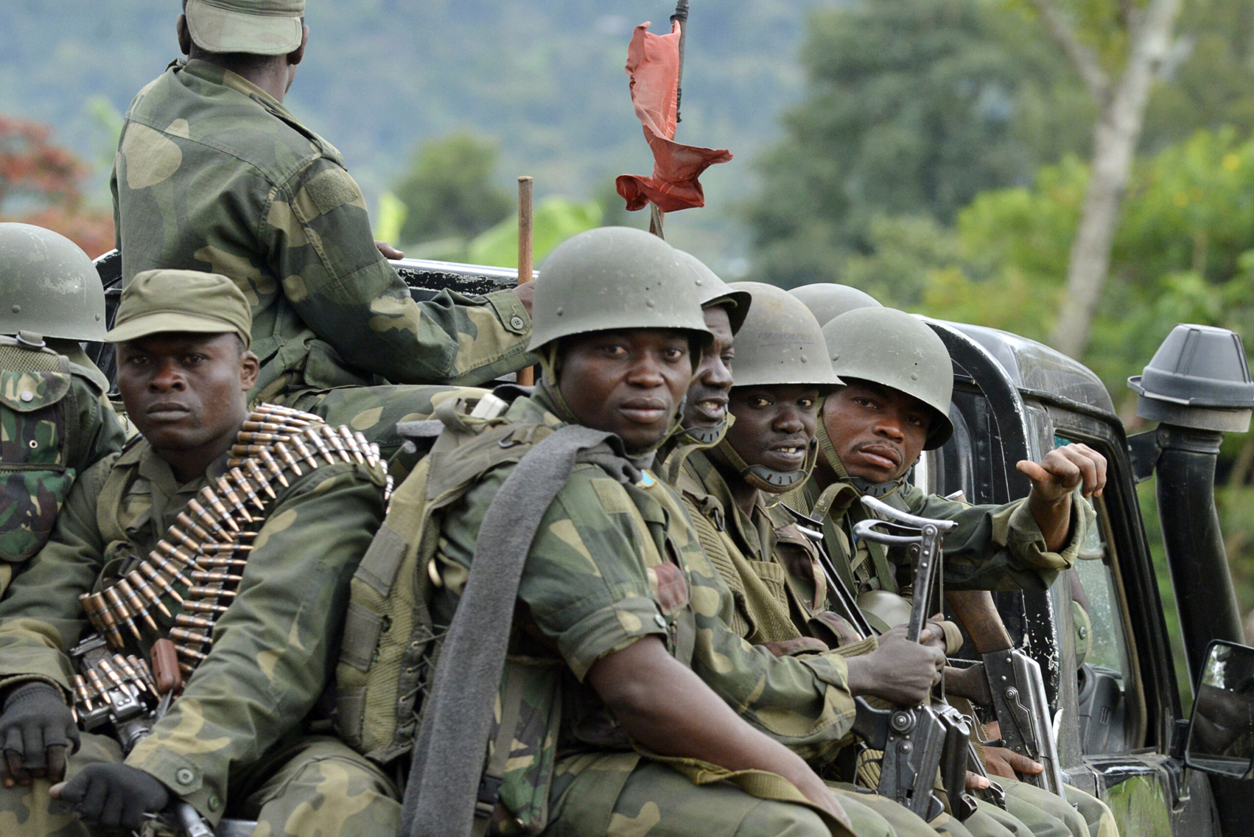 Democratic Republic of Congo army soldiers sit at the back of a pick-up truck as they head towards the Mbuzi hilltop