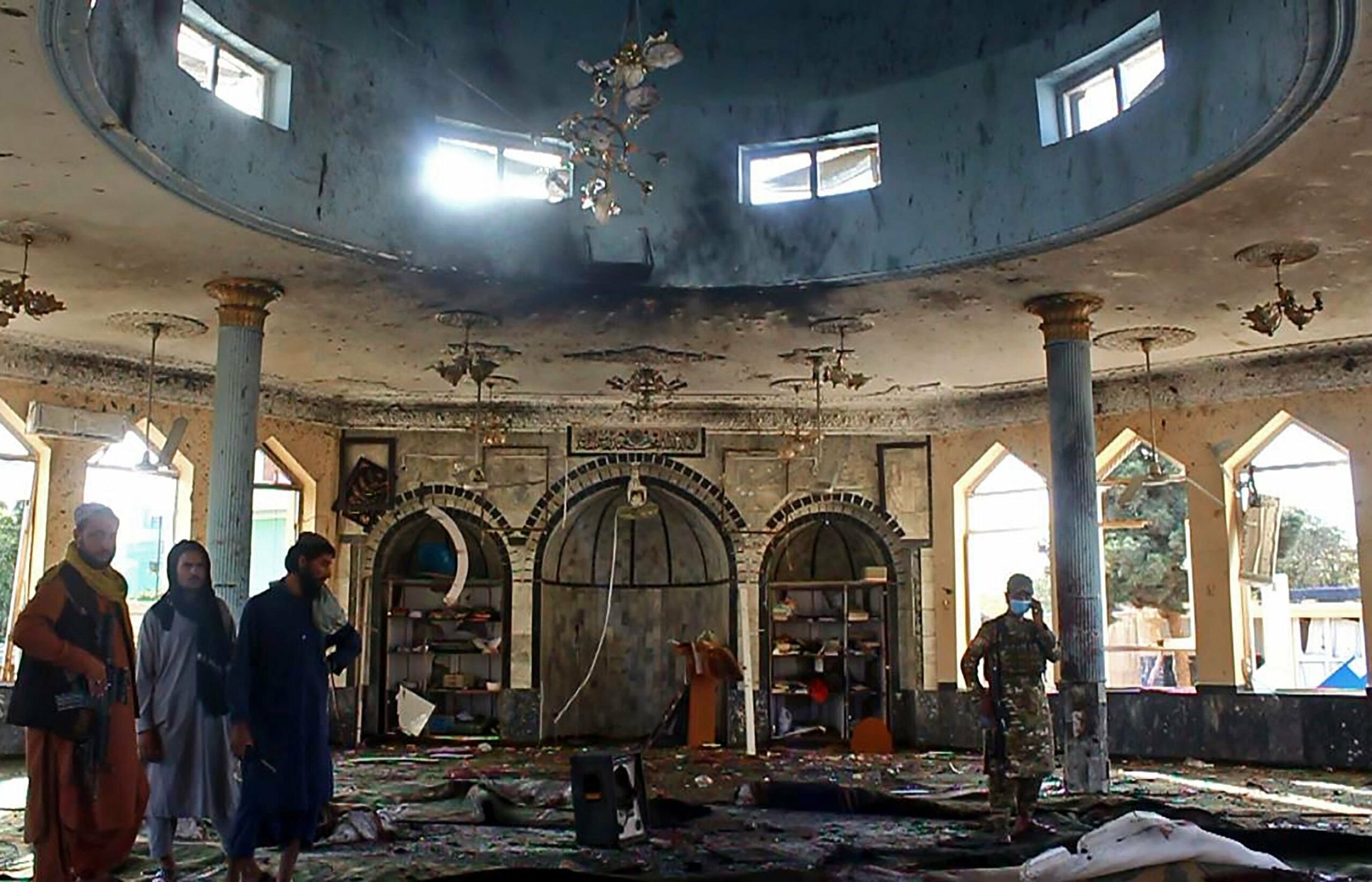 Taliban fighters investigate inside a Shiite mosque after a suicide bomb attack in Kunduz, Oct. 8, 2021