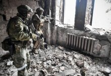 Two Russian soldiers patrol in the Mariupol drama theatre
