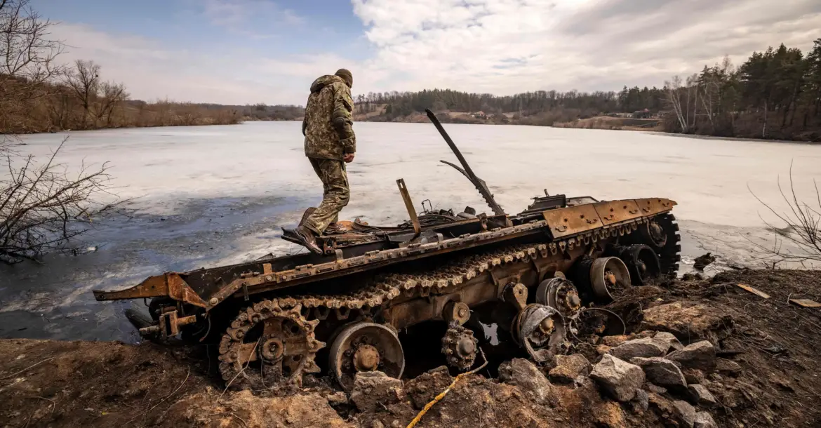 Ukrainian servicemember on destroyed Russian tank