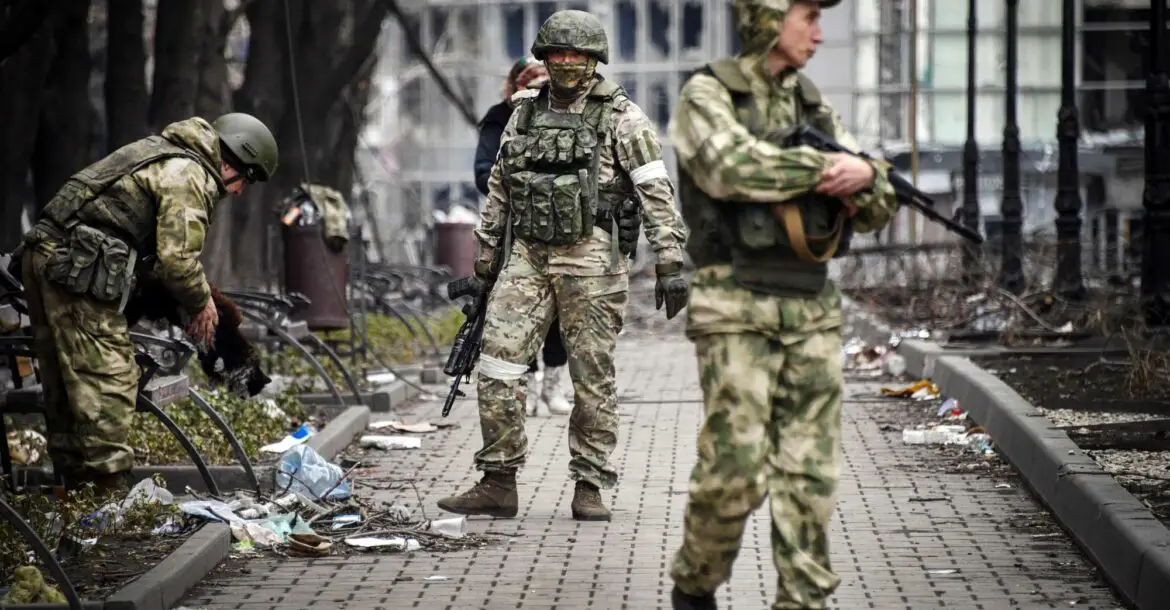 Russian soldiers walks along a street in Mariupol