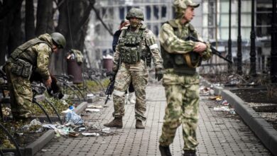 Russian soldiers walks along a street in Mariupol