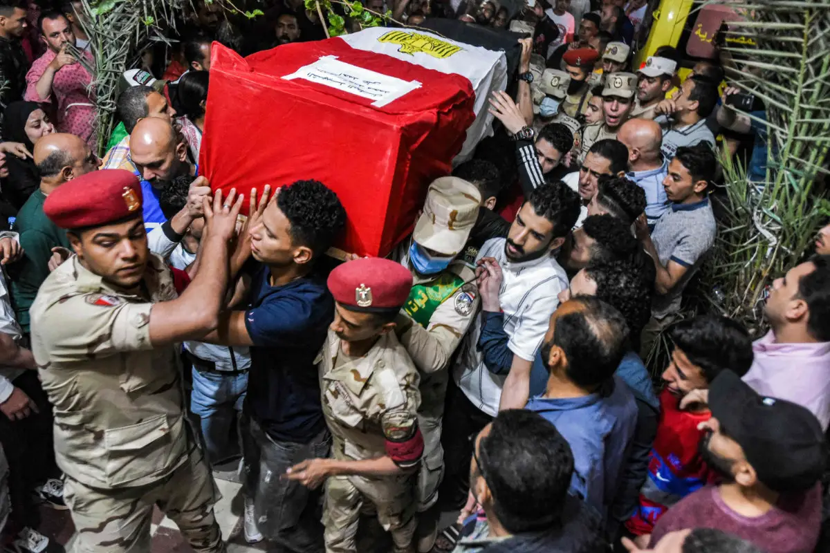 Mourners and soldiers carry the casket of one of 11 Egyptian soldiers killed in an attack