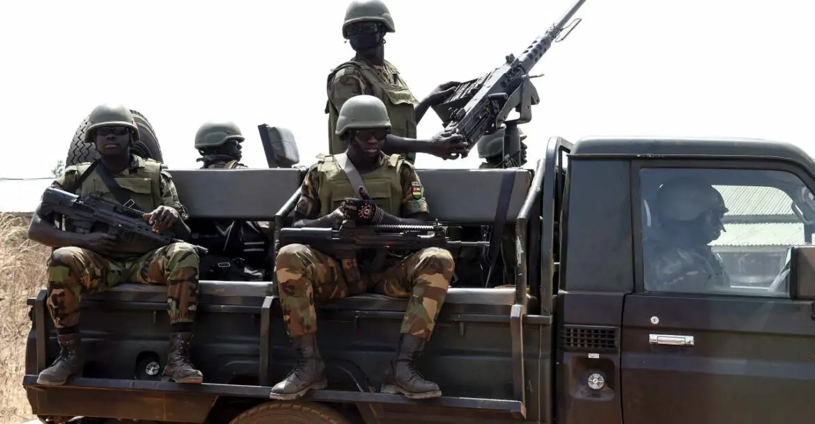 Togolese soldiers stand guard as they patrol at Namoundjoga village in northern Togo