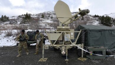 U.S. Army Spc. James Osids (right) and Sgt. Jerrick Thomas from Charlie Company, 307th Expeditionary Signal Battalion calibrate a satellite transportable terminal dish at Site Summit at Joint Base Elmendorf-Richardson, Alaska