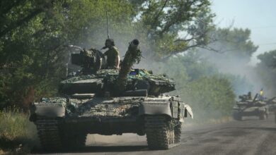 Ukrainian troop move by tanks on a road