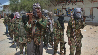 Al-Qaeda linked al-shabab recruits walk down a street on March 5, 2012 in the Deniile district of Somalian capital, Mogadishu