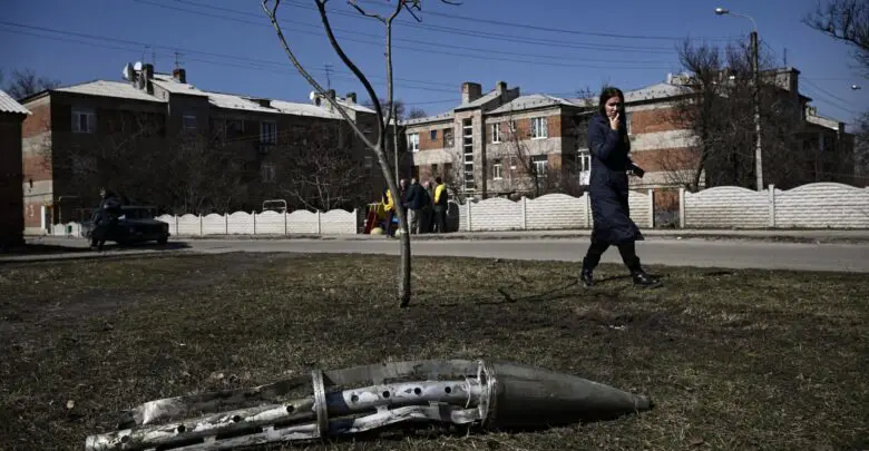 A woman looks at the remains of a missile in Ukraine's Kharkiv