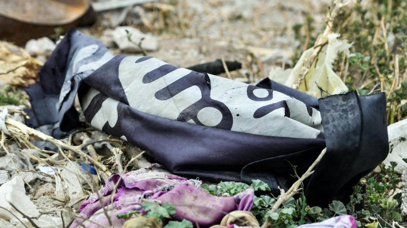 A discarded Islamic State flag lying on the ground in the Syrian village of Baghouz