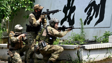 Taiwanese civilians in tactical gear and replica weapons take part in an urban warfare workshop on June 18, 2022