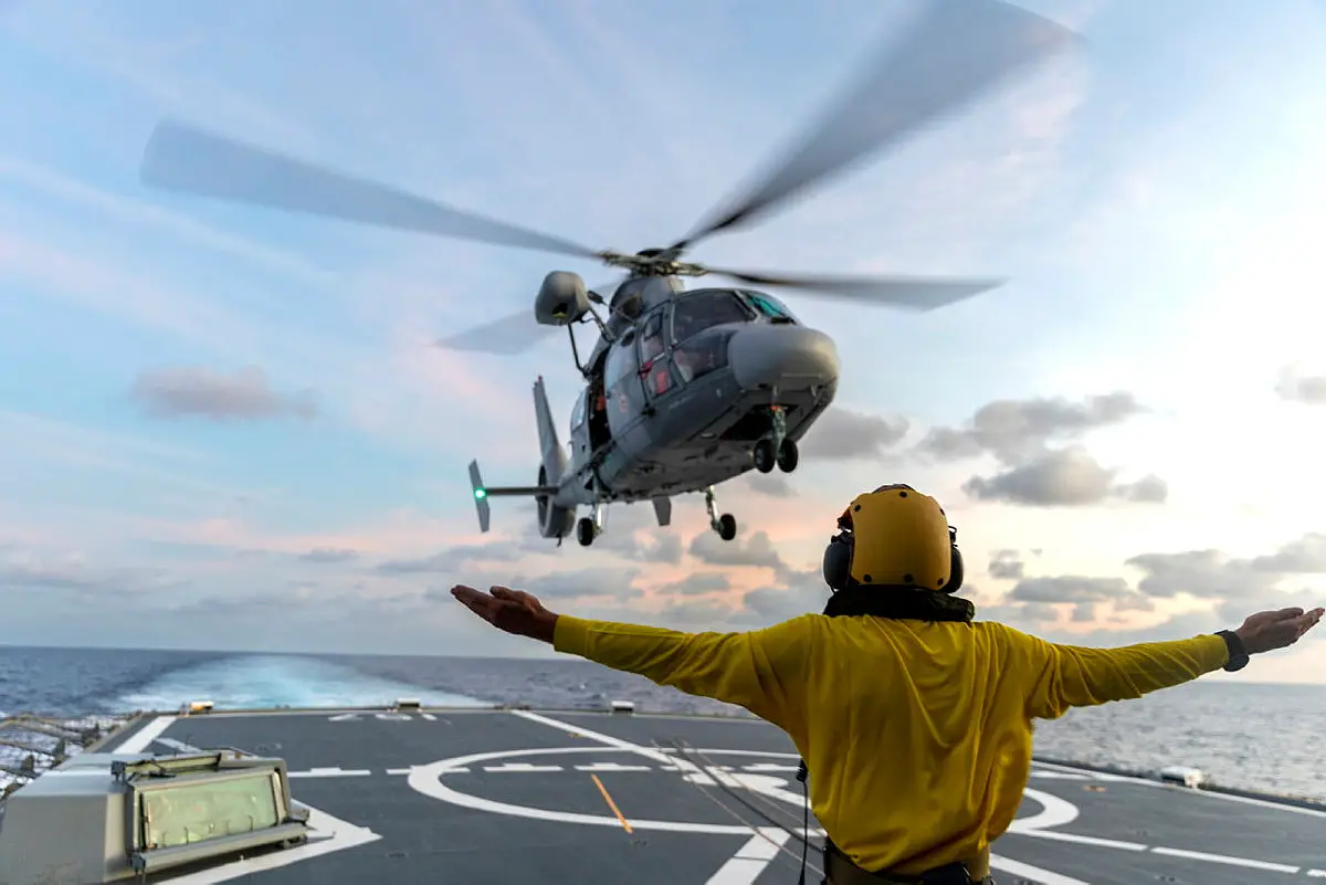 HMAS Perth's flight deck marshaller boatswains mate guides a French Navy Dauphin SA-365N helicopter
