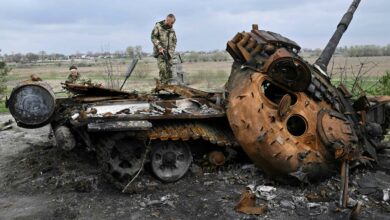 Ukrainian servicemen on a destroyed Russian tank