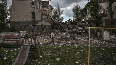 A man walks in front of a destroyed school in the city of Bakhmut, in the eastern Ukrainian region of the Donbas