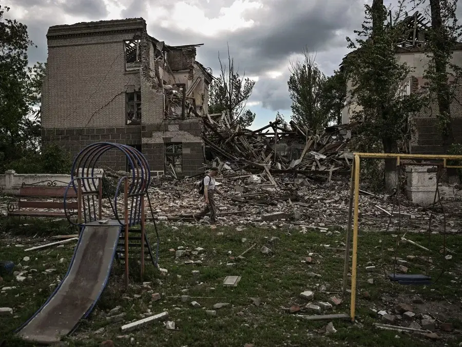 A man walks in front of a destroyed school in the city of Bakhmut, in the eastern Ukrainian region of the Donbas