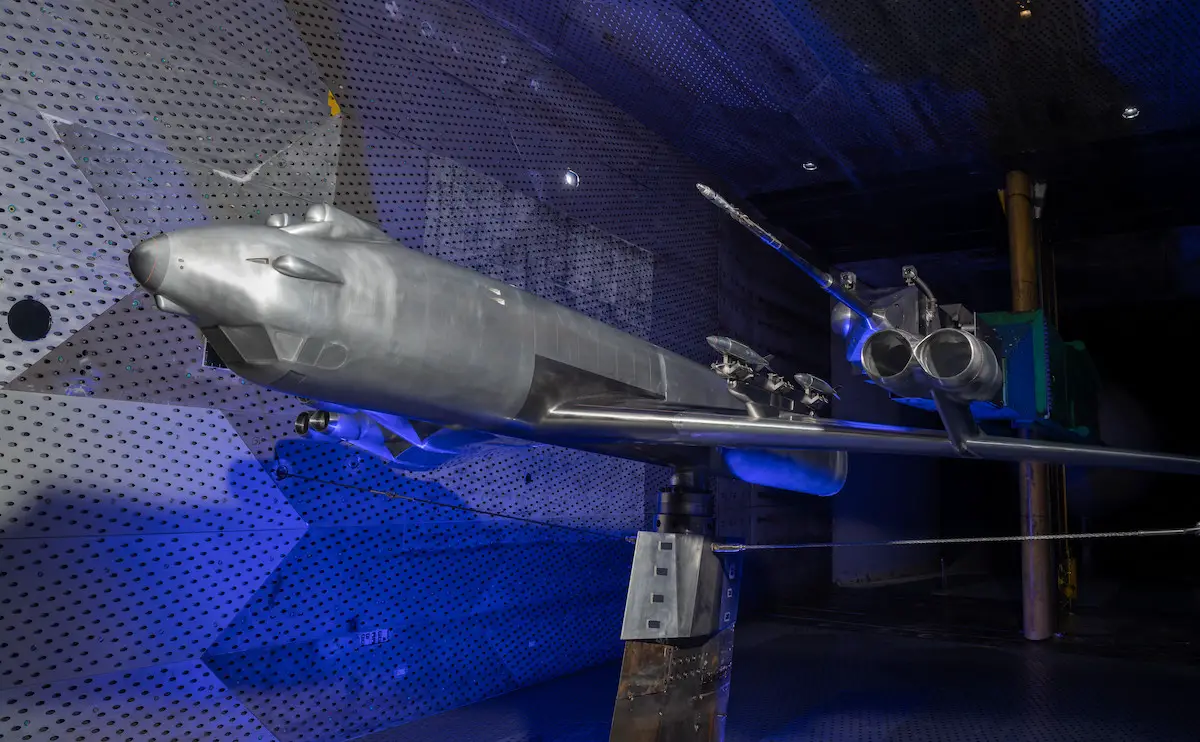 scale model of a GBU-38 mounted on a sting is positioned above a scale model of a B-52 Stratofortress 