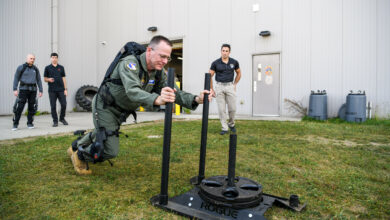 USAF 711th Human Performance Wing commander pushes a weighted sled while wearing the pneumatically-powered exoskeleton
