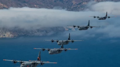 California Air National Guard C-130J Super Hercules aircraft fly in tight formation the Pacific Ocean, California