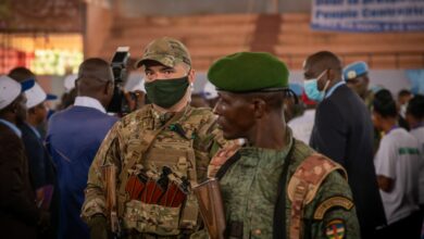A private security guard from the Russian group Wagner stands next to a Central African Republic soldier during a rally