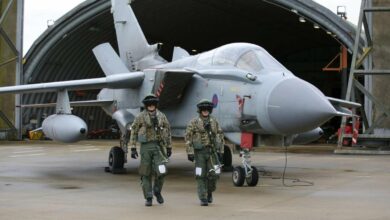Pilots walk in front of a Tornado GR4 at the British Royal Air Force airbase RAF Marham in Norfolk
