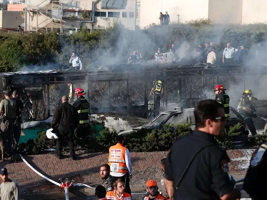 Israeli security forces and emergency services gather around a burned-out bus following the explosion in Jerusalem