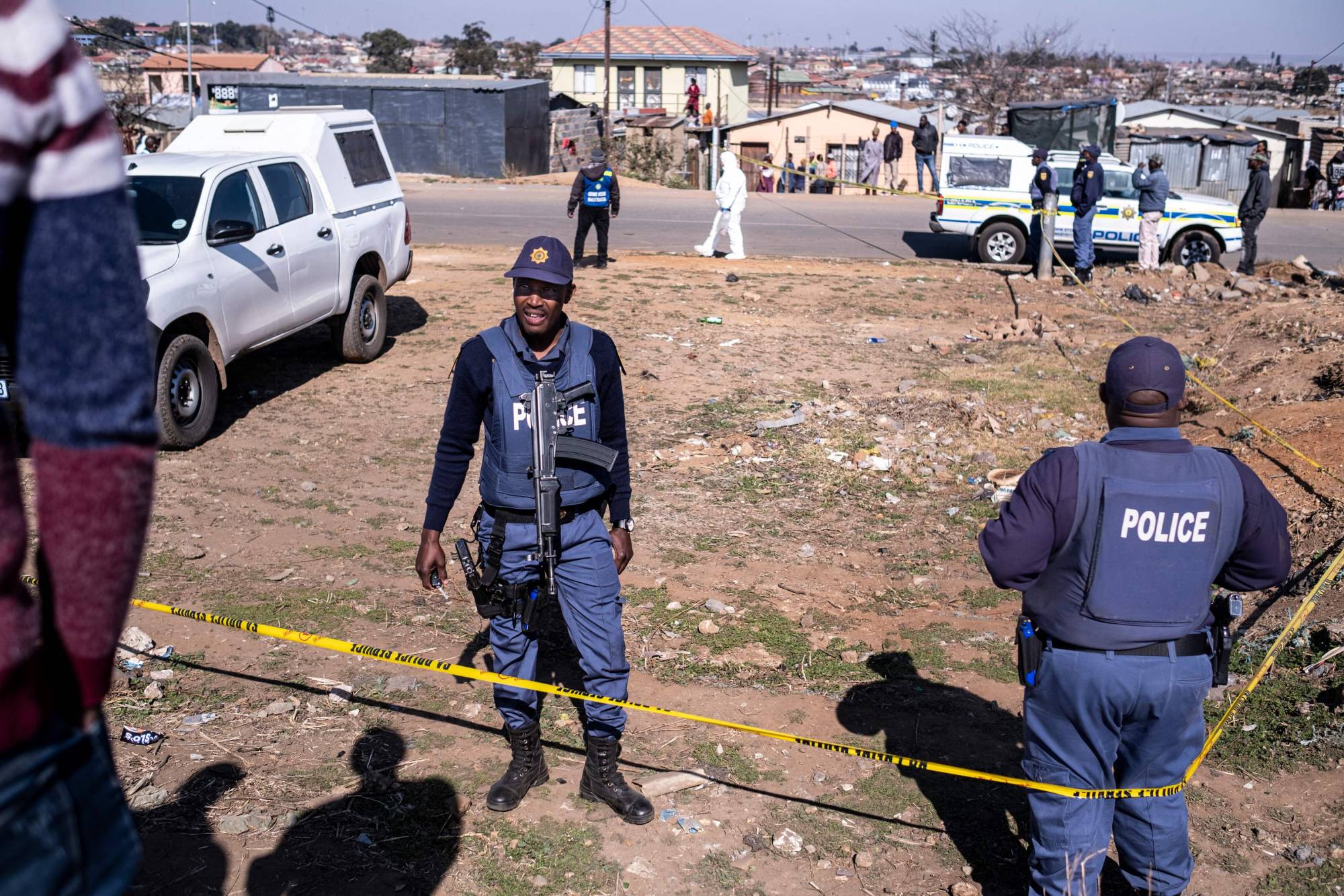South African Police Service (SAPS) officers enforce a perimeter around a crime scene in South Africa