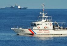 A Philippines' coast guard ship sailing past a Chinese coast guard ship during a joint search and rescue exercise between the Philippines and US coast guards near Scarborough Shoal in the South China Sea