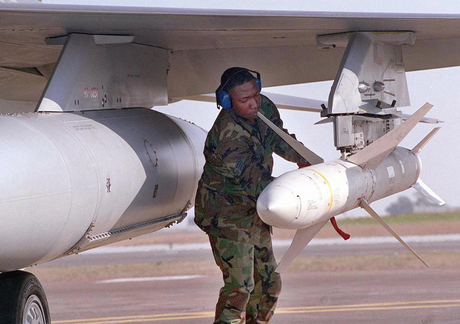 A US weapons technician secures an AGM-88 high-speed anti-radar missile