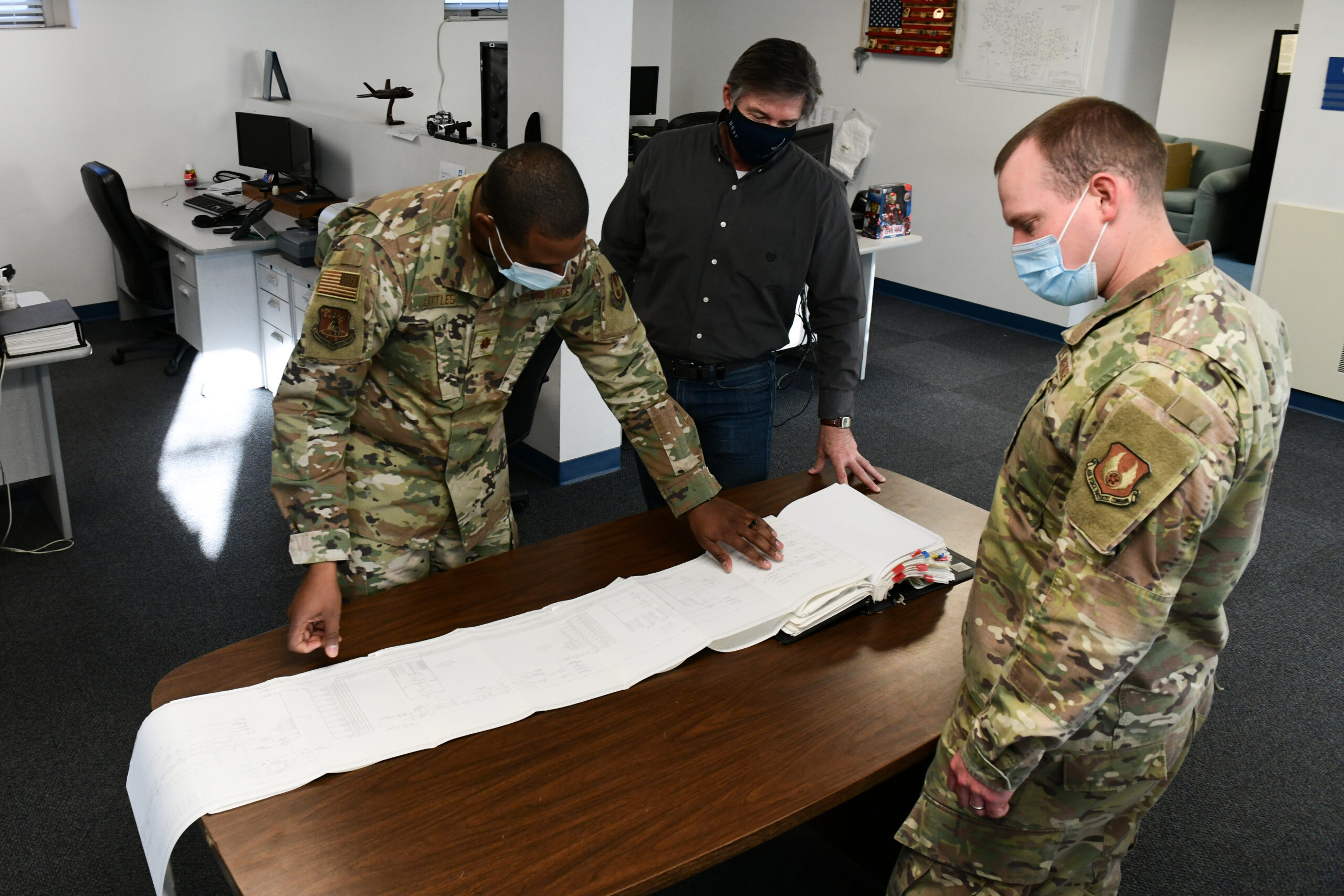 ICBM Technical engineers from the Air Force Nuclear Weapons Center out of Hill Air Force Base, Utah, look over documents that will allow them to help the 90th Maintenance Group with any problems they come across, Dec. 7, 2021, at F.E Warren AFB, Wyoming. The technical engineering squadron at Hill AFB, Utah has an office located at F.E Warren AFB, Wyoming in order to provide the local maintenance squadron with the help they need to complete their day-to-day mission. (U.S. Air Force photo by Airman Sarah Post)