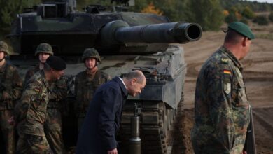 German Chancellor Olaf Scholz walks past a Leopard 2 battle tank