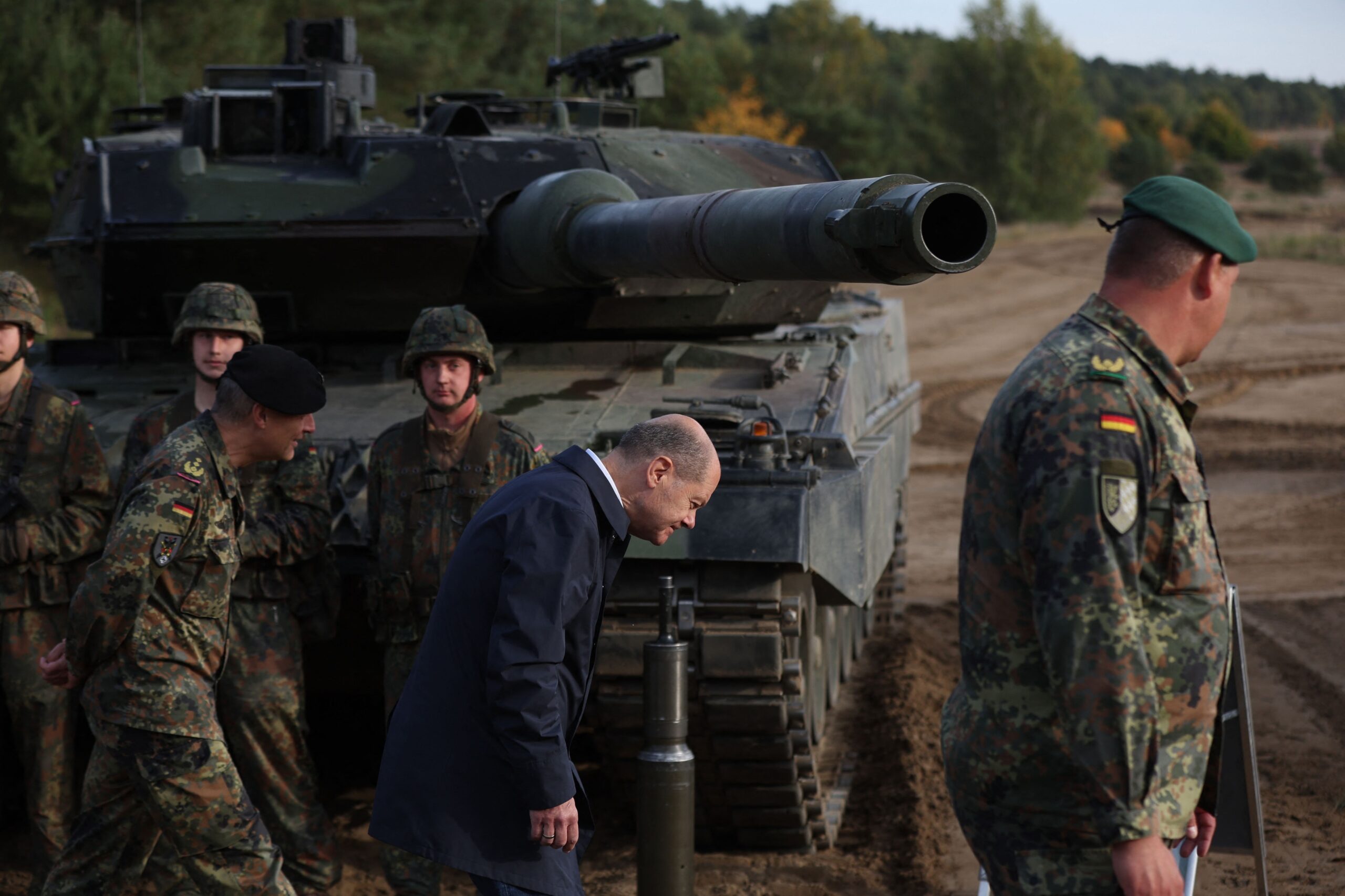 German Chancellor Olaf Scholz walks past a Leopard 2 battle tank