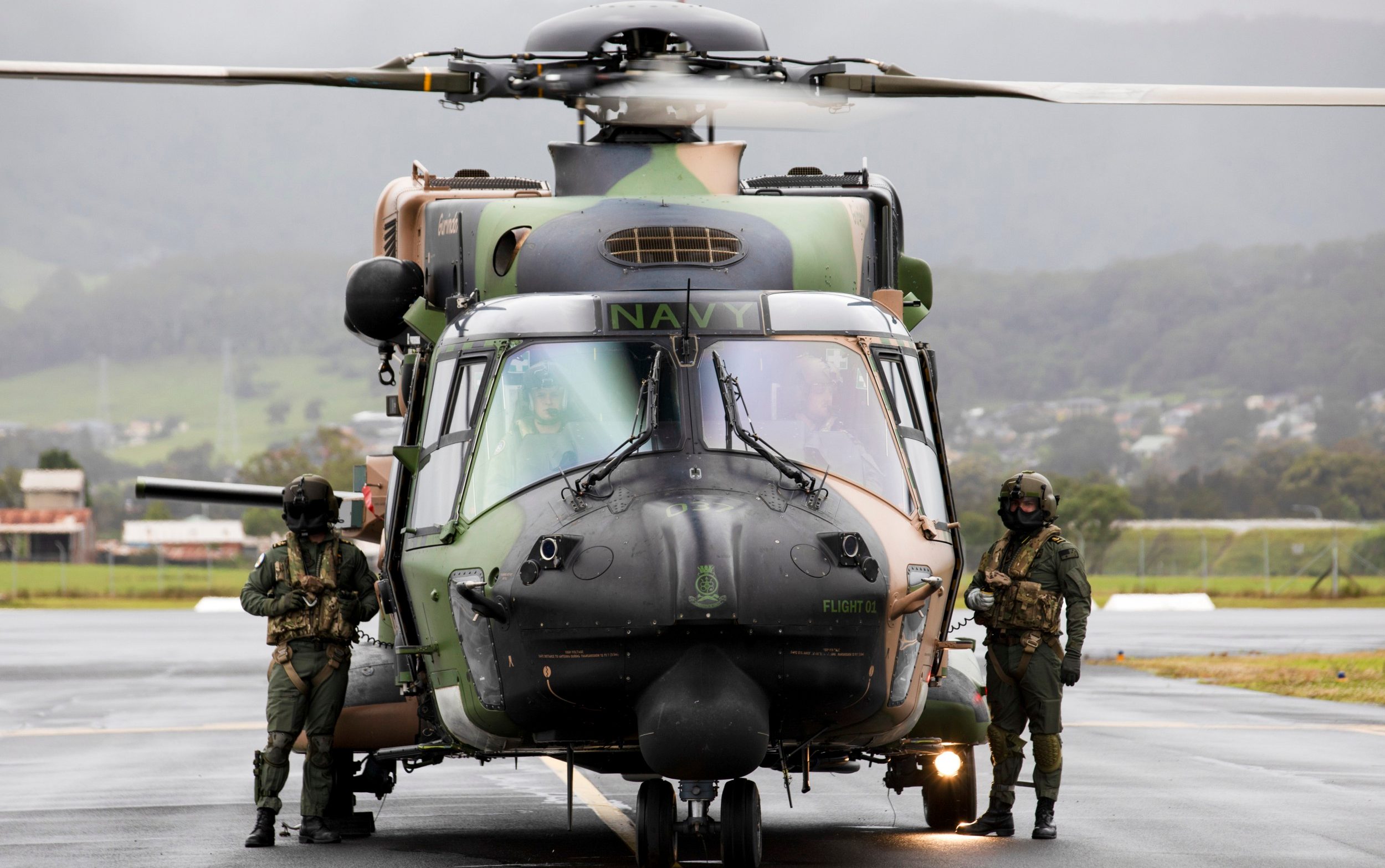 Royal Australian Navy aircrew from the 808 Squadron, stand beside their MRH90 Taipan helicopter in Wollongong, Australia