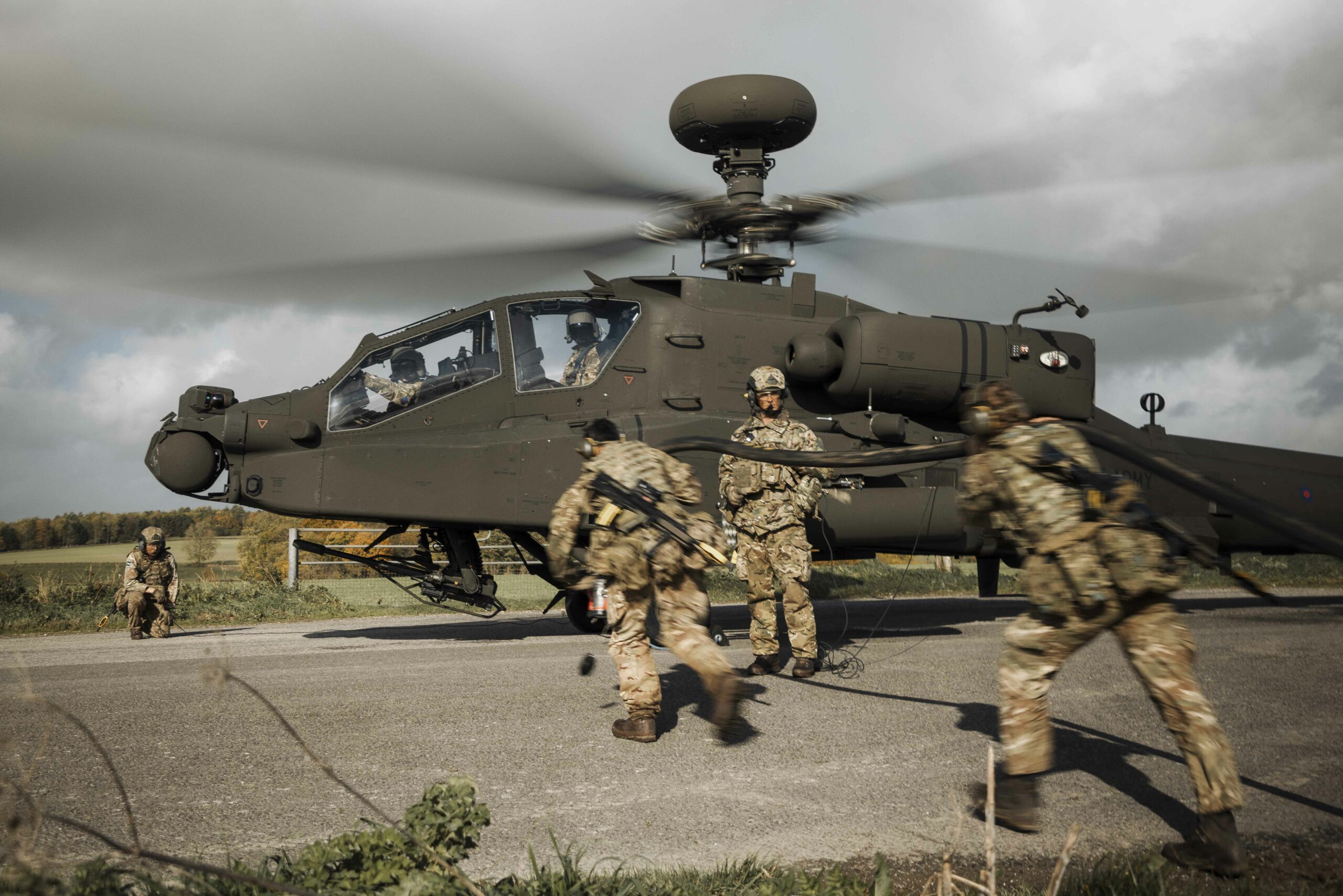 Groundcrew running Forward Arming and Refuelling Points keep the Apache's fuel tanks and weapons pylons full.