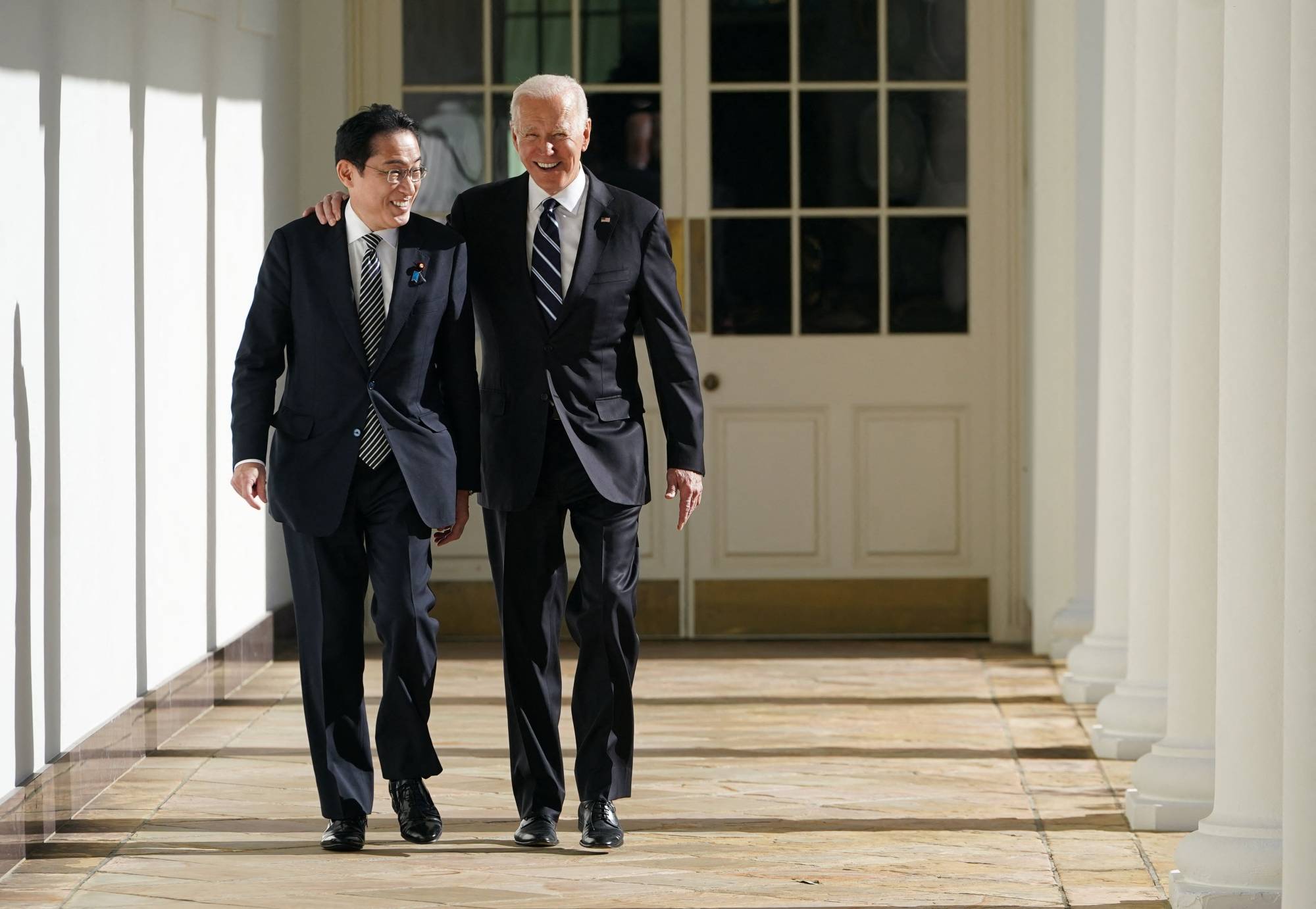US President Joe Biden and Prime Minister Fumio Kishida walk through the colonnade of the White House in Washington