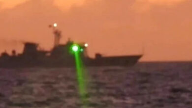 A Chinese coast guard vessel shines a "military grade laser light" at a Philippine coast guard boat in the disputed South China Sea