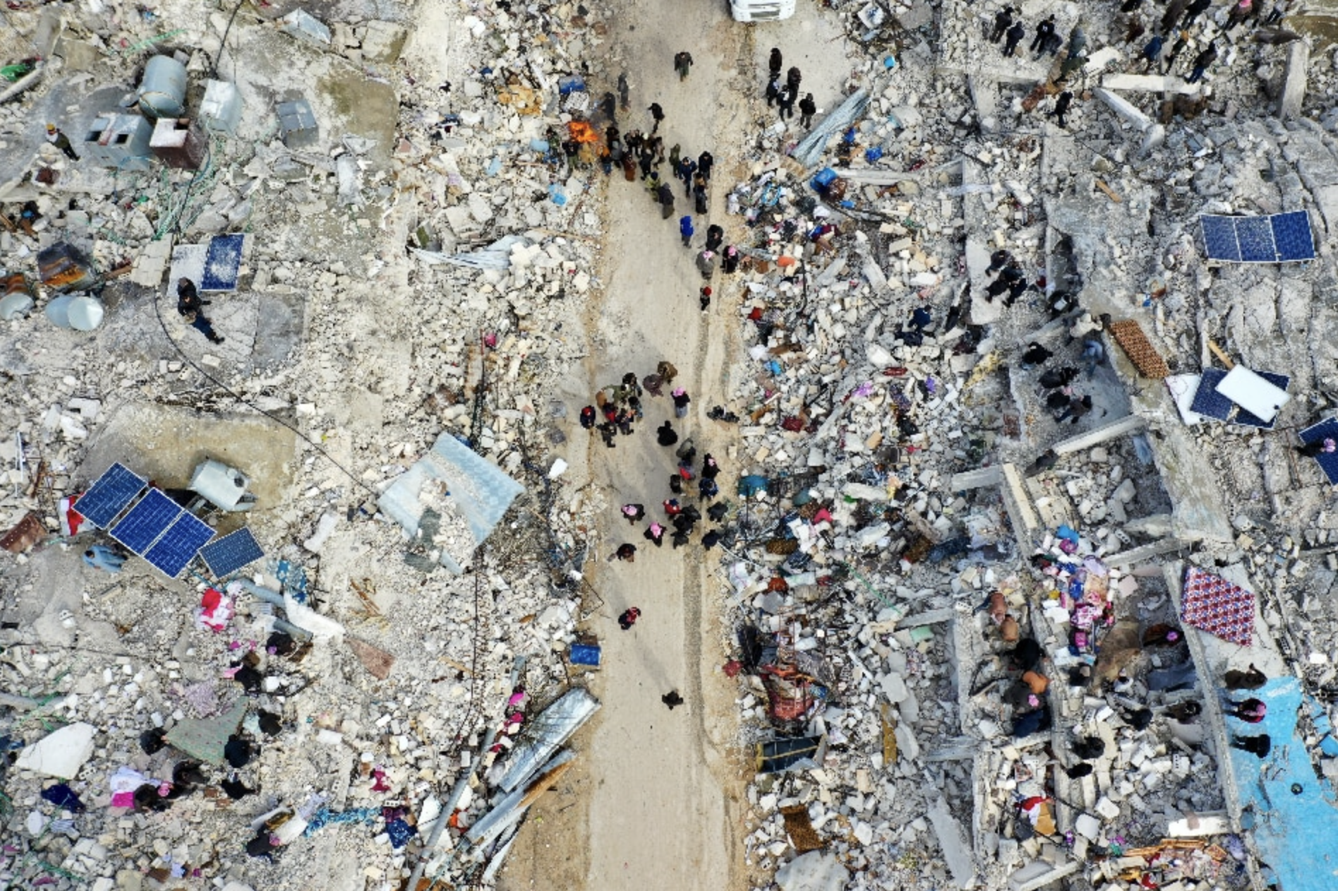 This aerial view shows residents searching for victims and survivors amidst the rubble of collapsed buildings following an earthquake in the village of Besnia near the twon of Harim, in Syria's rebel-held northhwestern Idlib