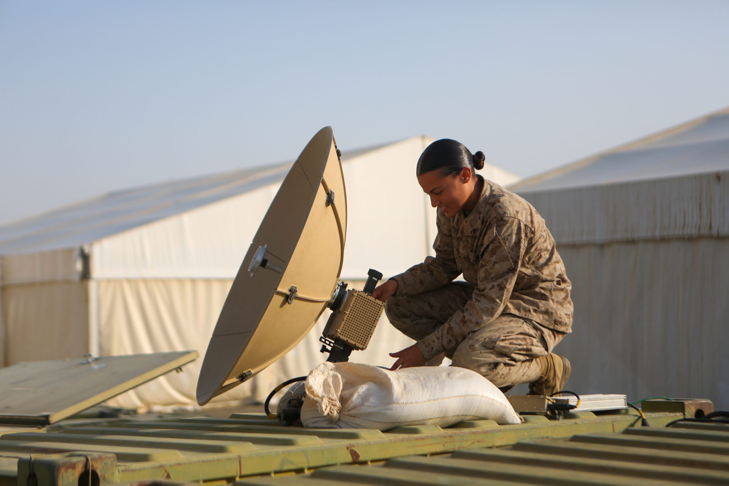 U.S. Marine Corps Lance Cpl. Yerika Zayasbonilla, a data systems administrator with Combat Logistics Regiment 1, 1st Marine Logistics Group, adjusts the satellite on the Marine Corps Wideband Satellite Communications - Expeditionary during exercise Native Fury 22 at a Logistics Support Area established in the Kingdom of Saudi Arabia, Aug. 21, 2022. Native Fury 22 is a biennial exercise focused on the demonstration of the rapid offload and integration of a Maritime Prepositioned Force in the U.S. Central Command area of responsibility in support of regional security, crisis response, and contingency operations. (U.S. Marine Corps photo by Sgt. Alize Sotelo)
