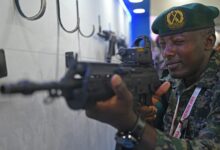 An African soldier checks a weapon at the weapon display session during Africa-India field training exercise (AFINDEX-2023), in Pune on March 29, 2023