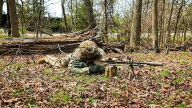 US soldier looks down sights of the new XM250 light machine gun