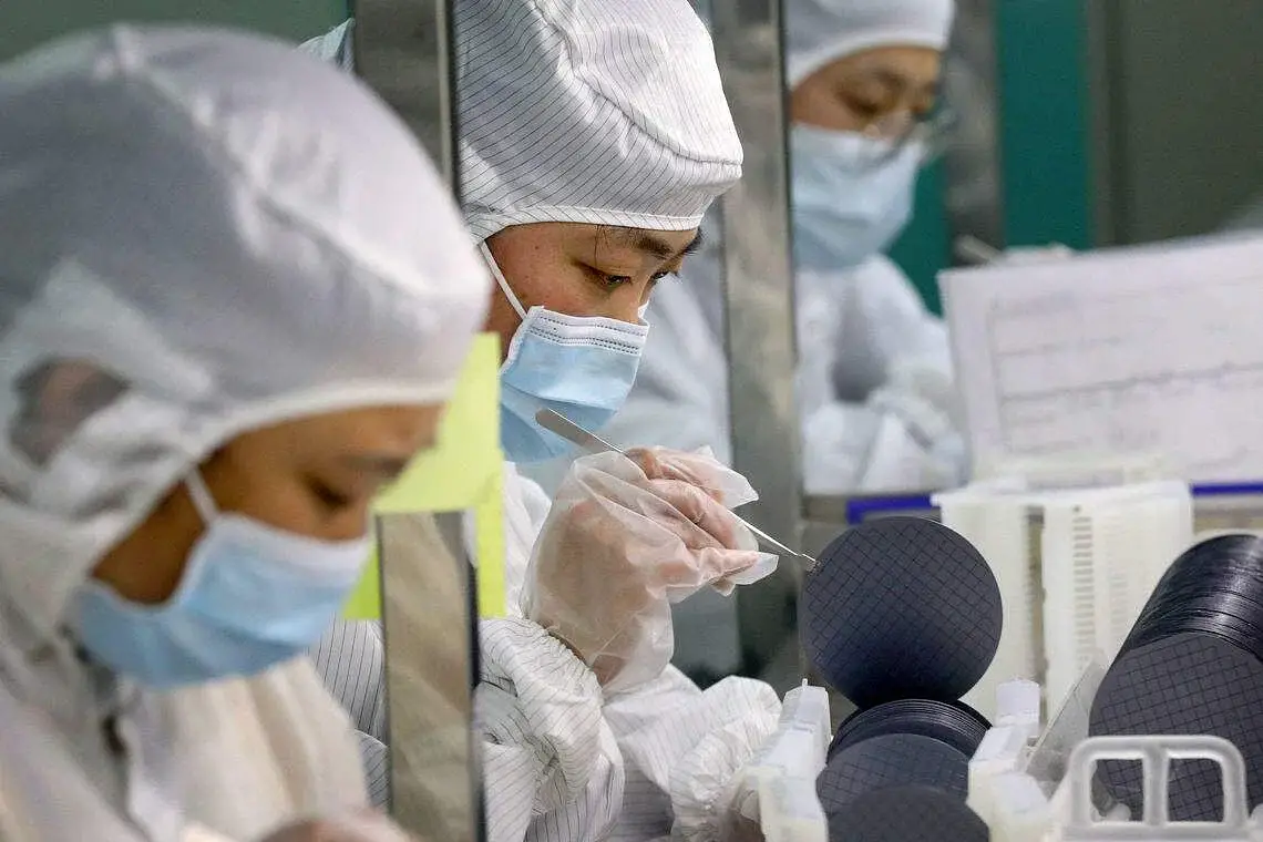 Employees make chips at a factory of Jiejie Semiconductor Company in Nantong, in eastern China's Jiangsu province
