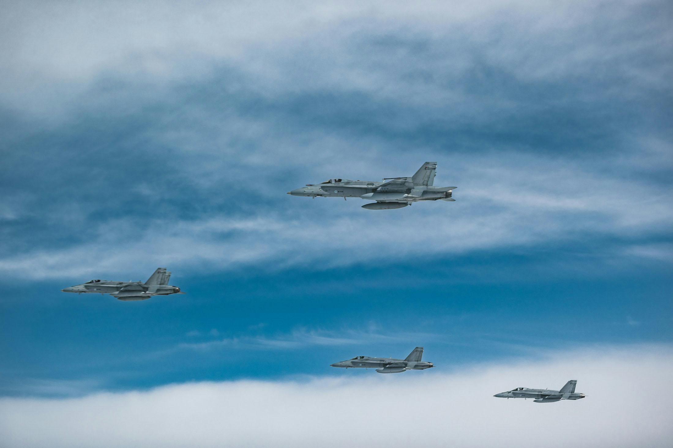Four Finnish F/A-18 fighters fly in formation.