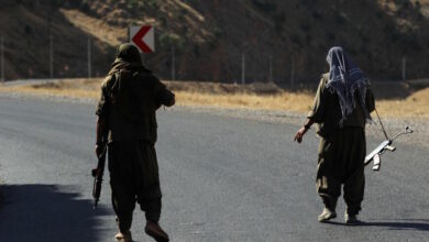 A member of the Kurdistan Workers' Party (PKK) carries an automatic rifle on a road in the Qandil Mountains, the PKK headquarters in northern Iraq, 2018