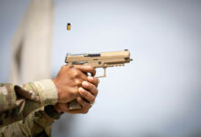 A cartridge exits the chamber after being fired from a SIG Sauer P320-M17, semi-automatic pistol during the Contract Operational Readiness Exercise (CORE) M17 qualifications at Camp Bullis in San Antonio, Texas, April 19, 2021. The CORE-21 serves as culminating events for Soldiers set to deploy within the coming months and next fiscal year. (U.S. Army photo by Spc. Eric Kestner / Released by Ms. Angele Ringo 377th Public Affairs Specialist).