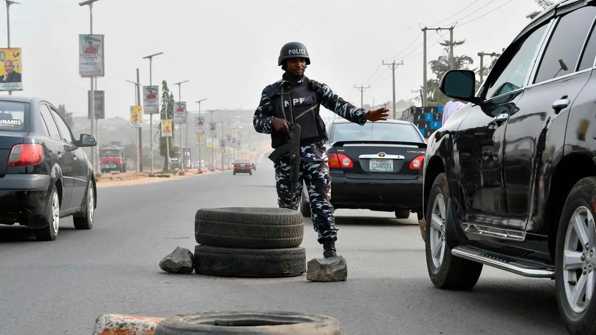 A police officer stops a car at a check point ahead of the February 25 presidential election at Awka in Anambra State, southeast Nigeria