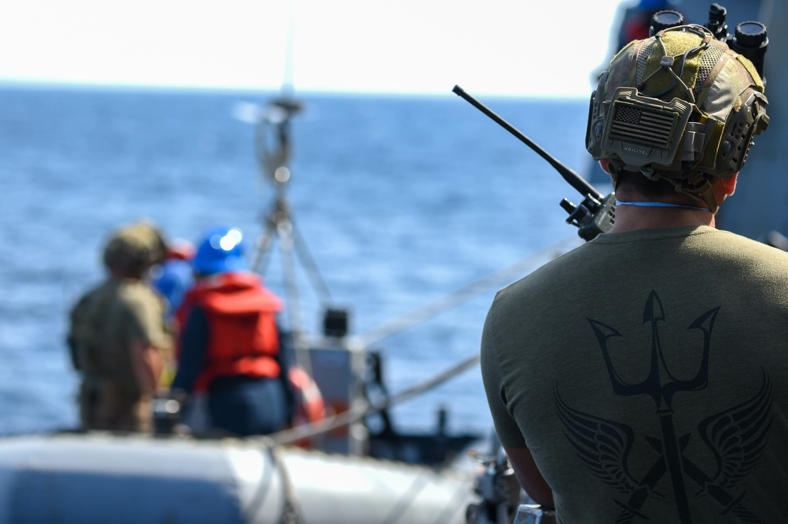 210830-N-UP745-1104 ATLANTIC OCEAN (Aug. 30, 2021) U.S. Coast Guardsman uses a two-way radio to direct a rigid-hulled-inflatable boat during a small-boat operation aboard the USS Forrest Sherman (DDG 98). Forrest Sherman is conducting Initial Ship Aviation Team Training with HSM-60 Detachment 2 in the Virginia Capes. (U.S. Navy Photo by Mass Communication Specialist Seaman Theoplis Stewart II/Released)