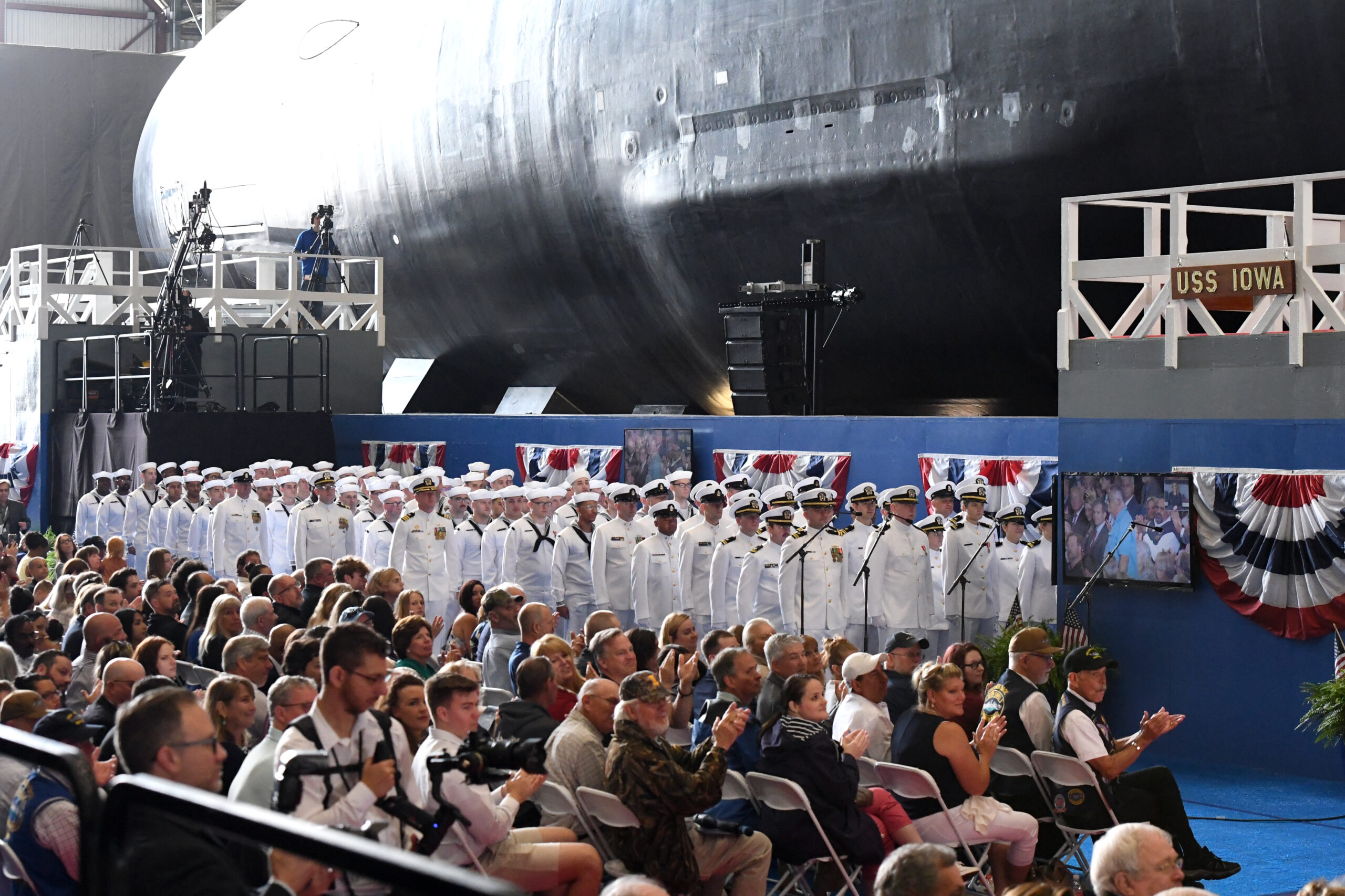 230617-N-UR986-0042 GROTON, Conn. (June 17, 2023) – The crew of the pre-commissioning unit (PCU) USS Iowa (SSN 897), stand in ranks next to their ship during a christening ceremony at General Dynamics Electric Boat shipyard facility in Groton, Conn., June 16, 2023. Iowa and crew will operate under Submarine Squadron (SUBRON) FOUR whose primary mission is to provide attack submarines that are ready, willing, and able to meet the unique challenges of undersea combat and deployed operations in unforgiving environments across the globe. (U.S. Navy photo by Petty Officer 2nd Class Wesley Towner)