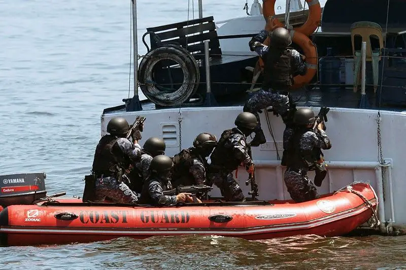 Philippine and Japanese Coast Guard personnel conduct a drill as they board a Philippine Coast Guard boat during their annual anti-piracy exercise in the waters off Manila Bay