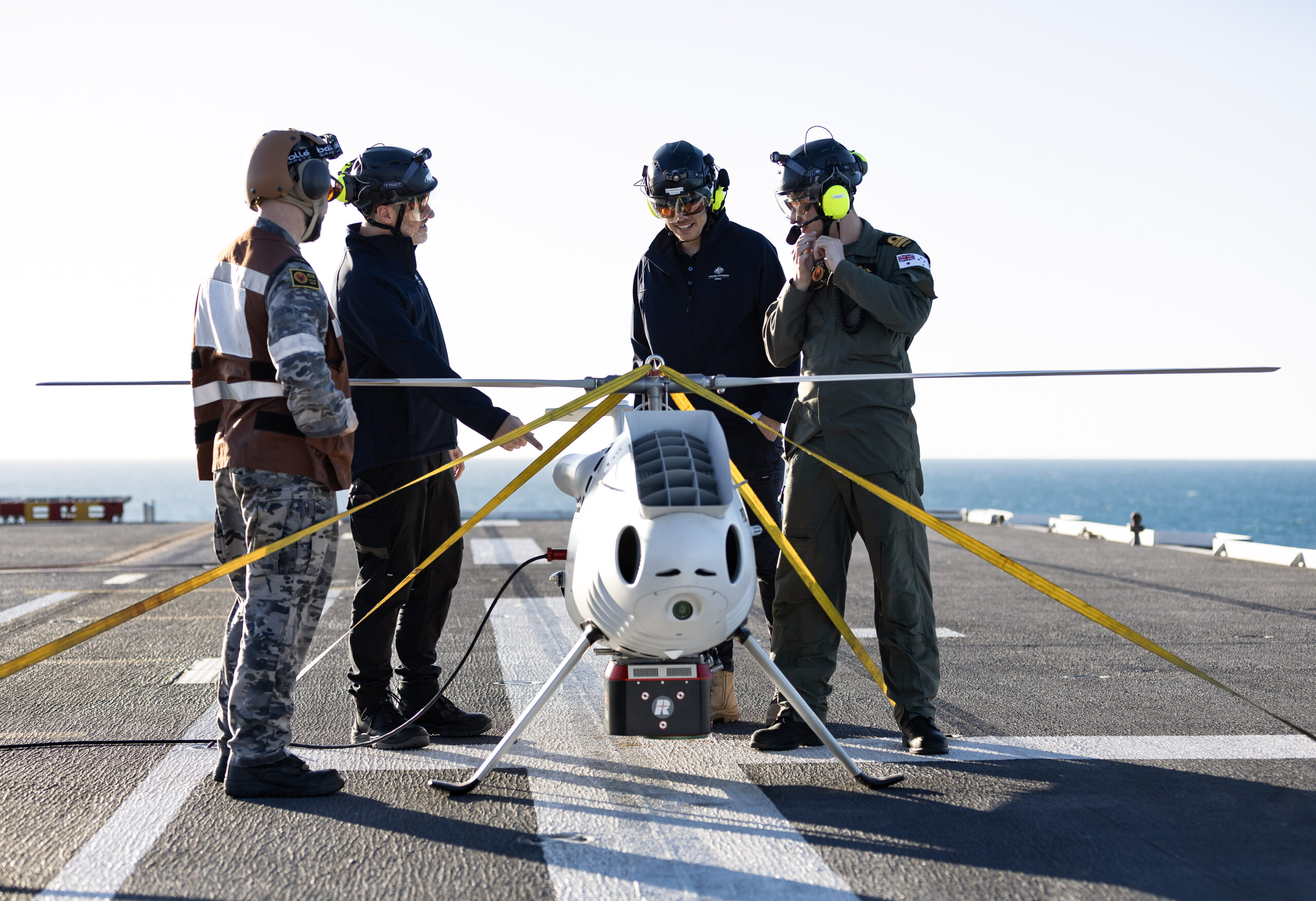 S100 Crew from 822X Squadron and Defence Science and Technology Group personnel discuss the S100 Bathymetric LiDAR Sensor trials on the Flight Deck of HMAS Adelaide during Exercise Sea Raider 23. *** Local Caption *** In July 2023 the Australian Defence Force conducted Exercise Sea Raider across the coast of North Queensland. Exercise Sea Raider certified the Amphibious Ready Unit and saw the Australian Amphibious Force train closely with the Royal Australian Navy's HMAS Adelaide and HMAS Choules, as well as a beach landing force comprising of infantry, armoured vehicles, artillery, aviation and logistic elements optimised for amphibious raids and assaults. The Sea Series of exercises enhances joint interoperability of the Australian Army and Royal Australian Navys amphibious capabilities.