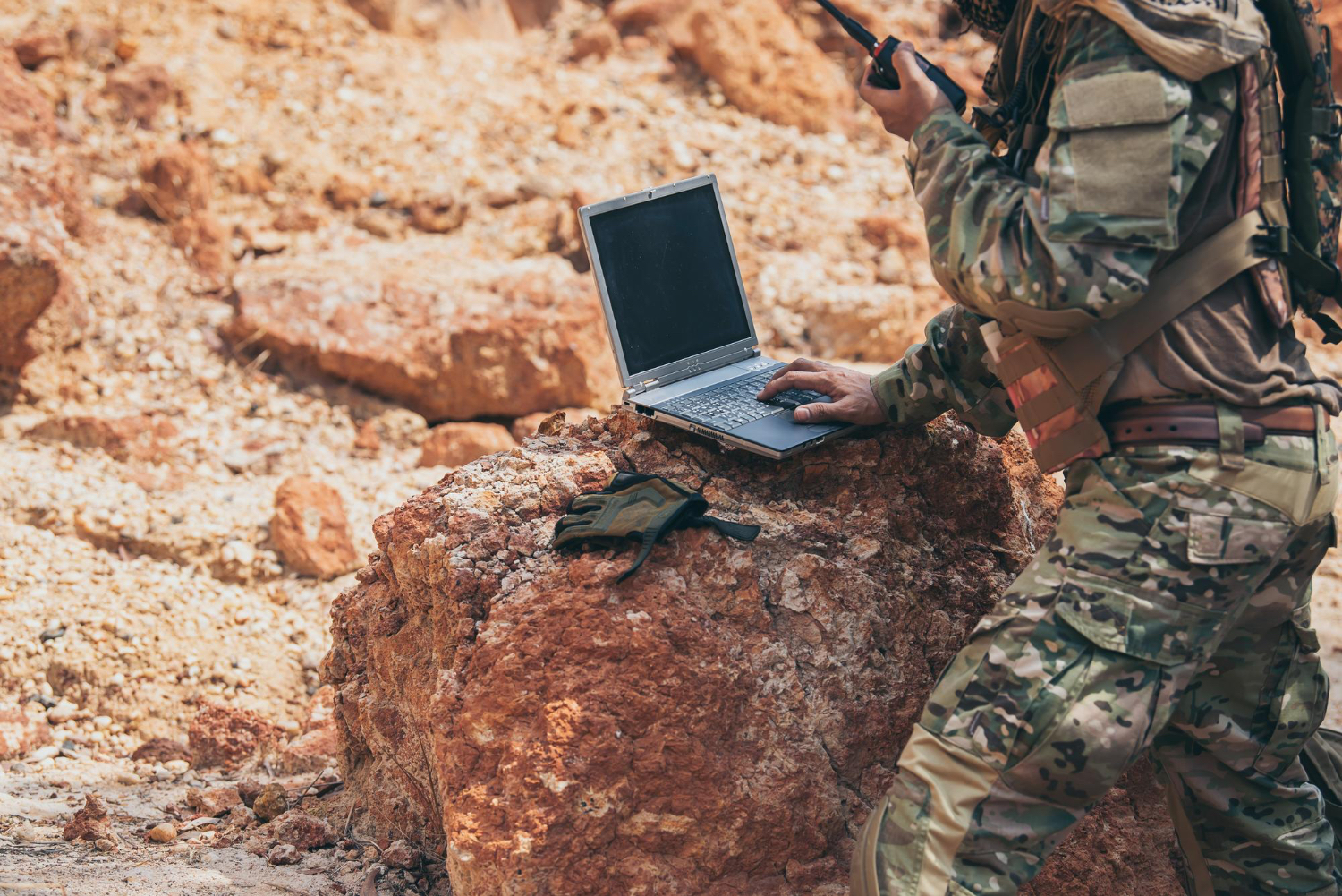Soldier using laptop on the battlefield
