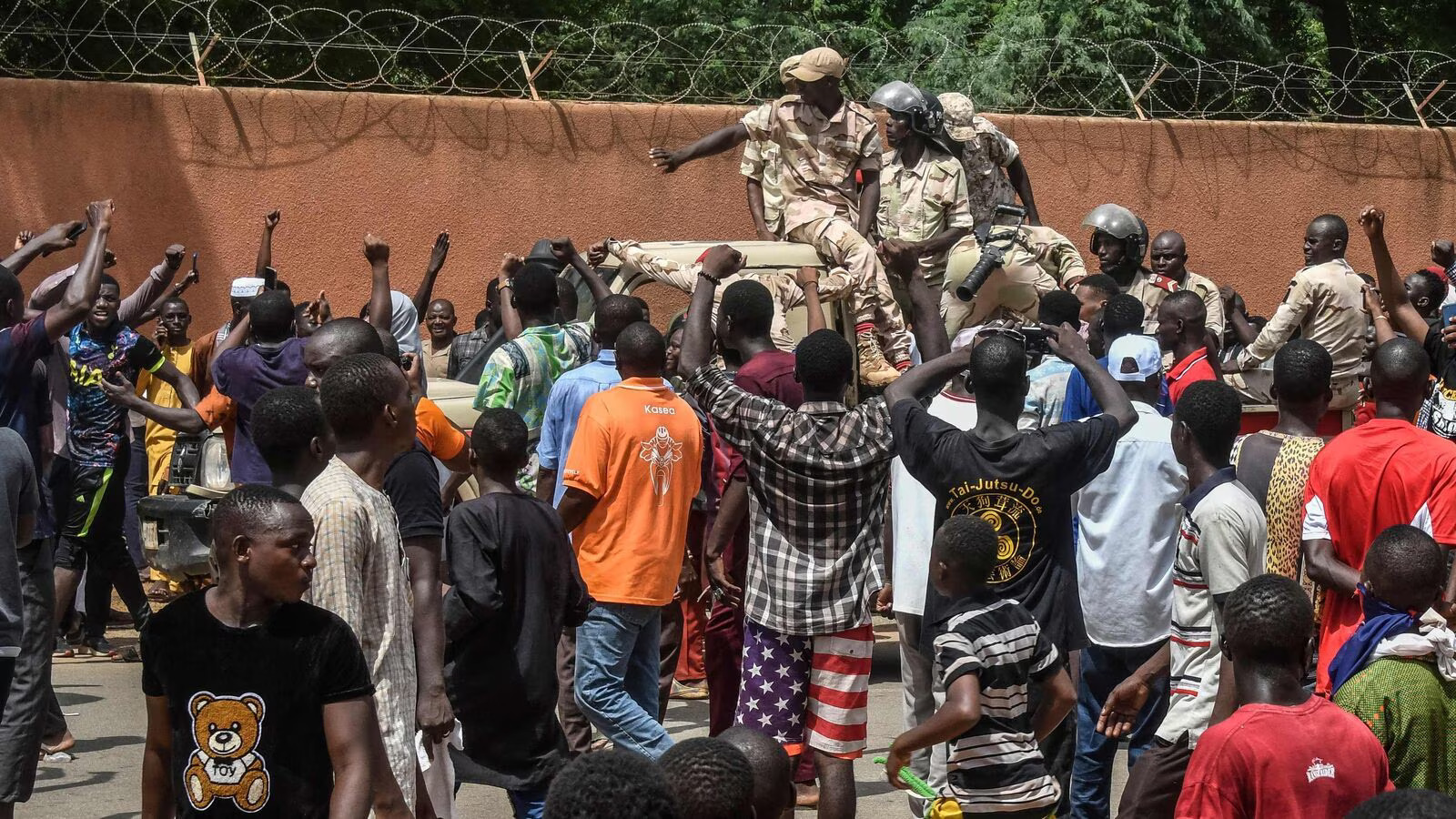 Protesters cheer Nigerien troops as they gather in front of the French Embassy in Niamey during a demonstration that followed a rally in support of Niger's junta in Niamey